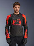 Alpinestars T-Stunt Air jakke, tekstil-motorcykeljakke, sort og rød, med stort stjernelogo og mesh-paneler for luftgennemstrømning, båret af model med sorte handsker