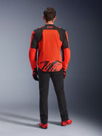 Set bagfra af MM93 T-SPS Air V2-jakken, neonrød og sort, tekstil motorcykeljakke med store mesh-paneler på ryggen til ventilation, båret med sorte bukser og rødt fodtøj, med Marc Marquez 93-branding
