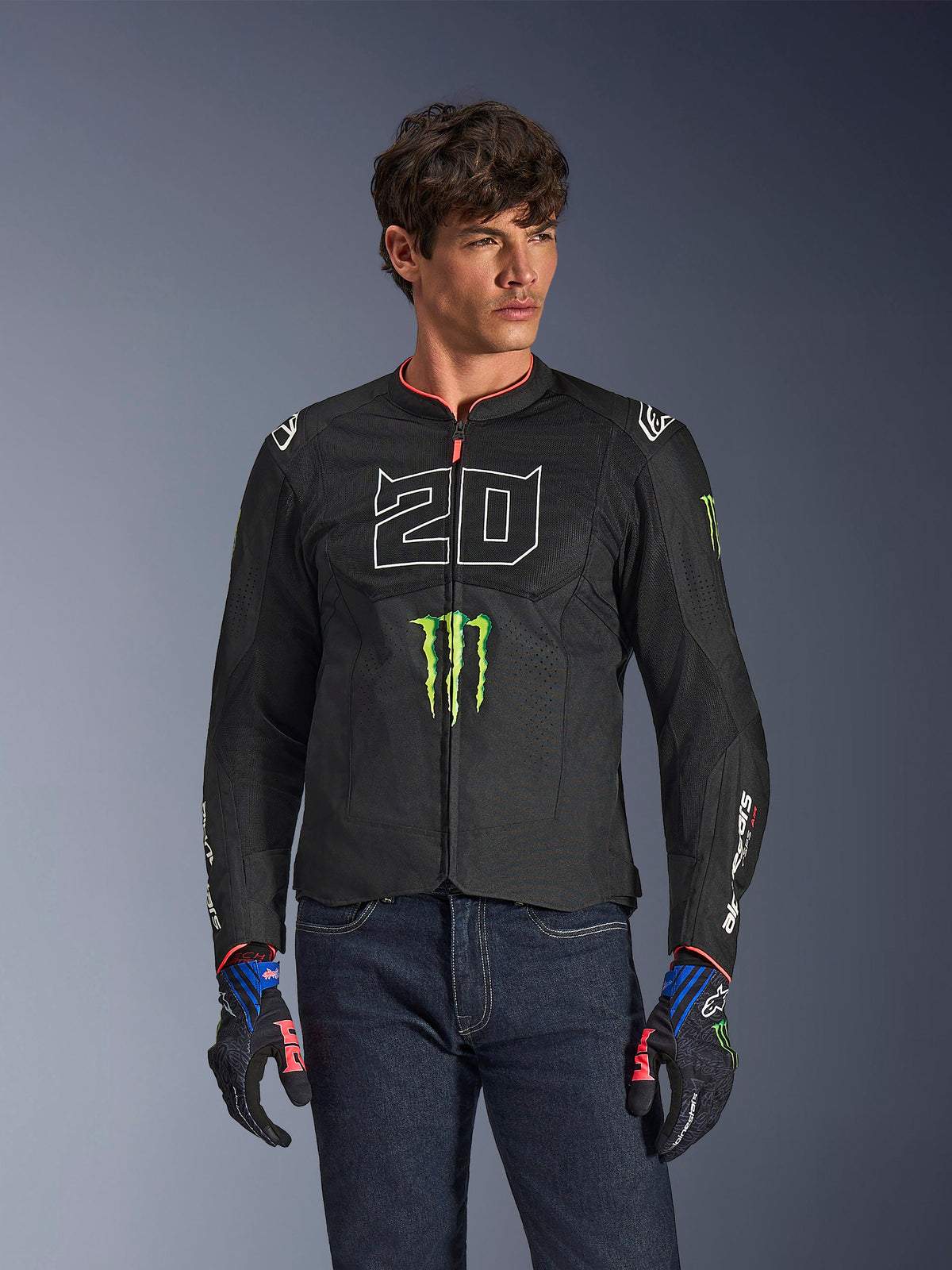Alpinestars FQ20 T-SPS Air V2 Monster-jakke, sort motorcykeljakke med stort hvidt '20' og grønt Monster Energy-logo, båret af en mandlig model med mørke jeans og matchende handsker, letvægts mesh-konstruktion til bykørsel