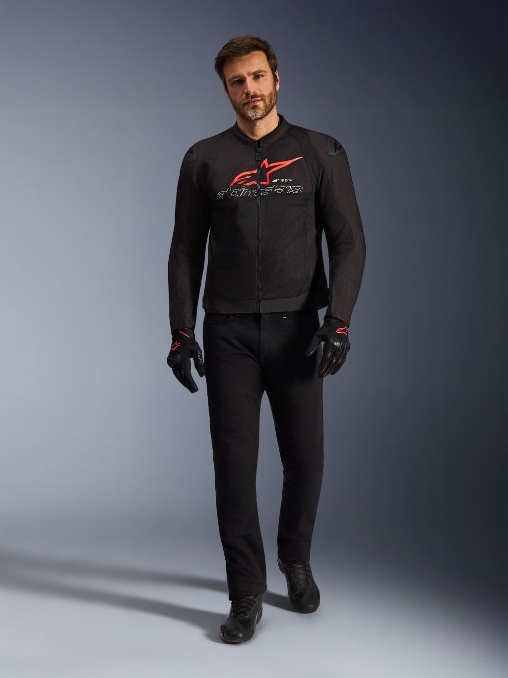 Alpinestars SMX Air jakke, sort, rød og hvid, sportsmotorcykeljakke båret med sorte kørebukser og handsker, med tekniske mesh-paneler og et markant rødt Alpinestars-logo på brystet, performance street-køreoutfit