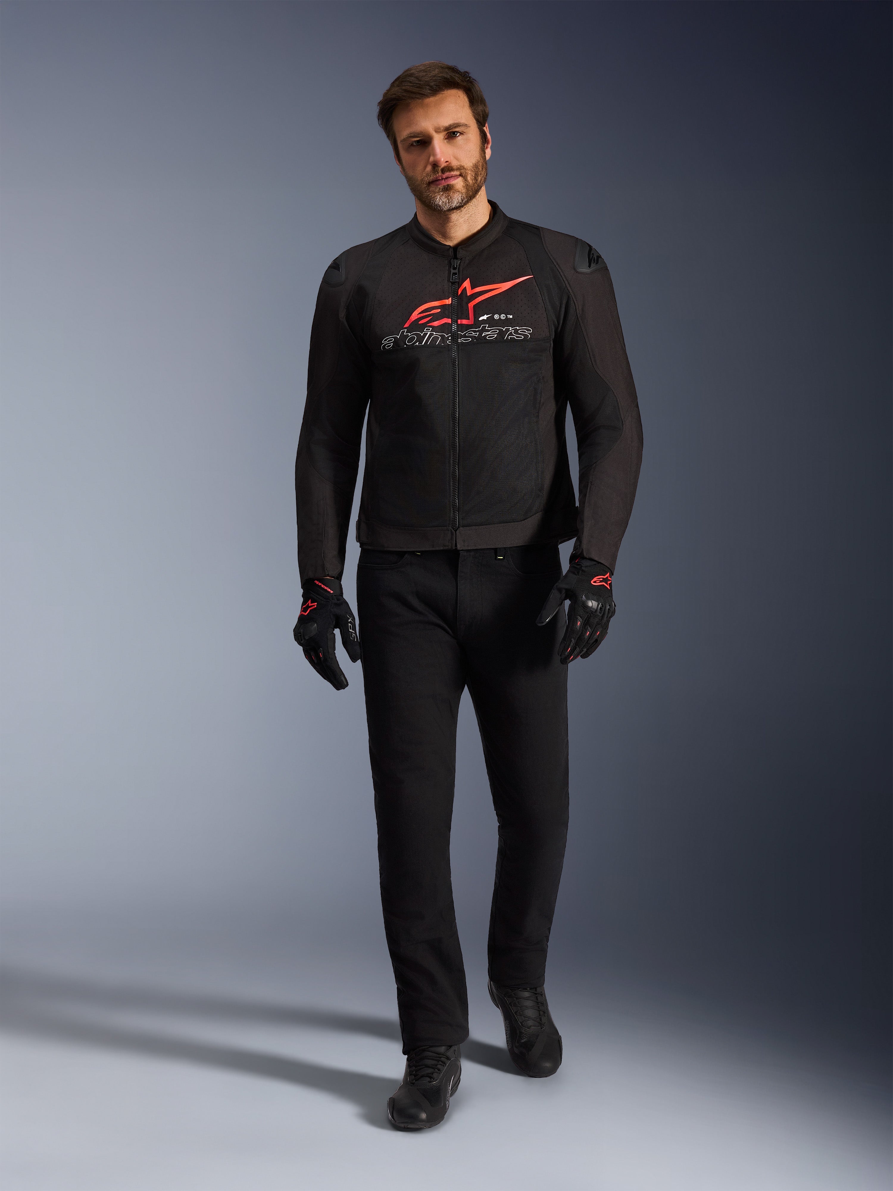 Alpinestars SMX Air jakke, sort, rød og hvid, sportsmotorcykeljakke båret med sorte kørebukser og handsker, med tekniske mesh-paneler og et markant rødt Alpinestars-logo på brystet, performance street-køreoutfit