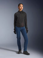 Kvindelig rytter iført Alpinestars Stella Aeroshell Airflow-jakken i sort, med laserperforeret ventilation og mesh-paneler, stylet med blå motorcykeljeans og sort motorcykeludstyr, moderne sportslig og urban køreæstetik