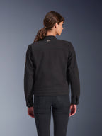 Alpinestars Stella Grace jakke til kvinder, sort, set bagfra, urban motorcykeljakke med klassisk arbejdstøjs-æstetik, tekstil polycotton twill-konstruktion, kombineret med sorte jeans
