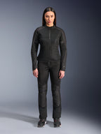 Kvinde iført Alpinestars Stella C-1 Air Jakke i sort, kombineret med matchende sorte tekstil-motorcykelbukser og køresko, med et stilrent urbant design med store mesh-paneler for luftgennemstrømning.