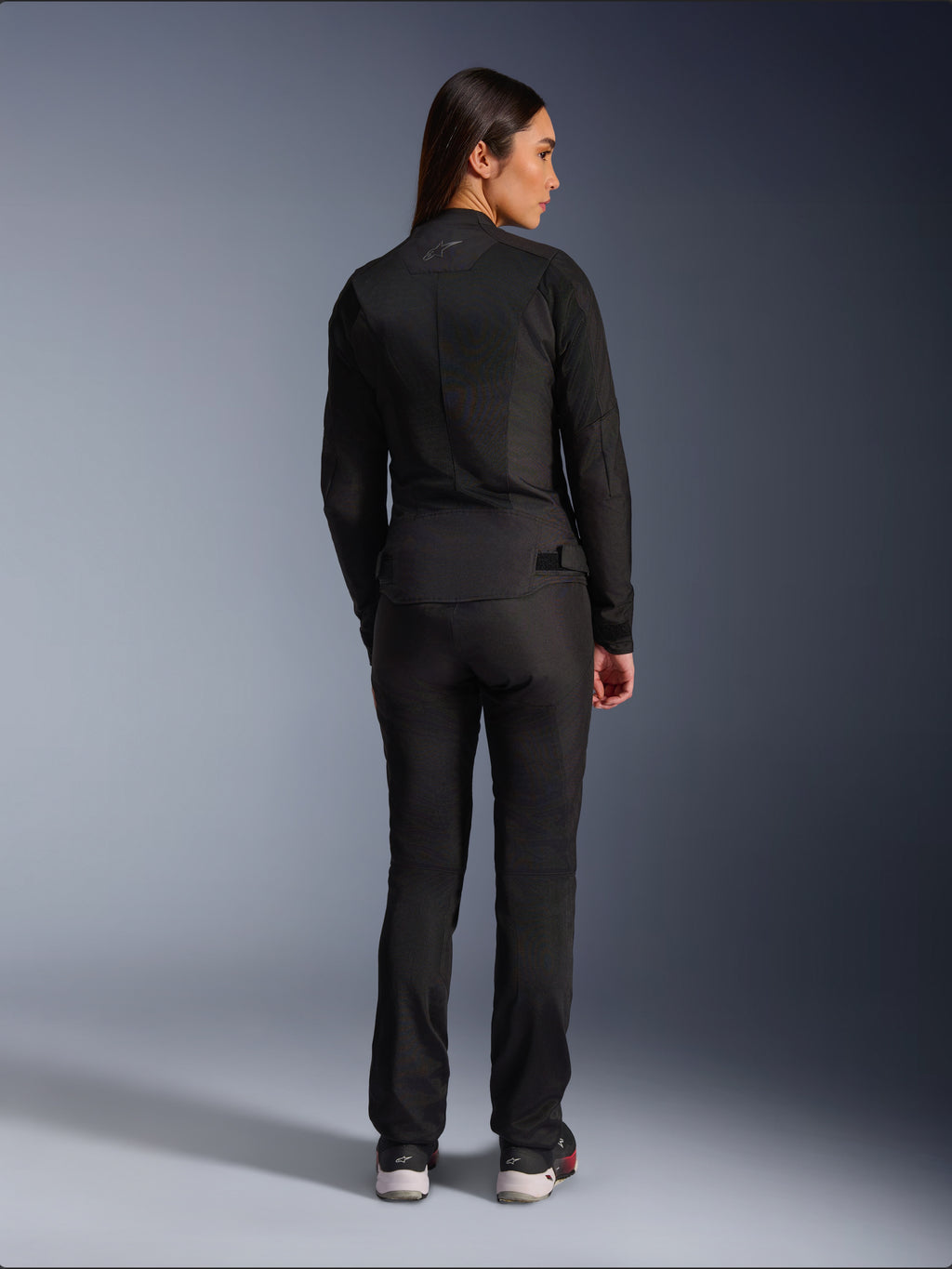Alpinestars Stella C-1 Air jakke, tekstilmotorcykeljakke til damer, sort, set bagfra med mesh-konstruktion og diskret logo øverst på ryggen, båret med matchende sorte mc-bukser, moderne urban stil