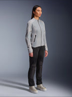 Kvinde iført Alpinestars Stella C-1 Air Jacket i Silver, letvægts tekstil- og mesh-motorcykeljakke, stylet med sorte motorcykelbukser og afslappede sneakers, ren urban køreæstetik