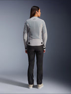 Alpinestars Stella C-1 Air-jakke til kvinder i sølv, set bagfra, med store tech mesh-paneler til ventilation og et reflekterende stjernelogo, kombineret med sorte motorcykelbukser og hvide sneakers, urbant moderne motorcykeludstyr