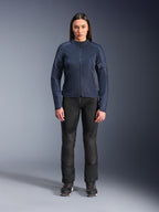 Kvindelig model iført Alpinestars Stella C-1 Air-jakke i blå, urban motorcykeljakke med tech mesh-paneler, kombineret med sorte motorcykelbukser og sorte sneakers, studiebillede set forfra