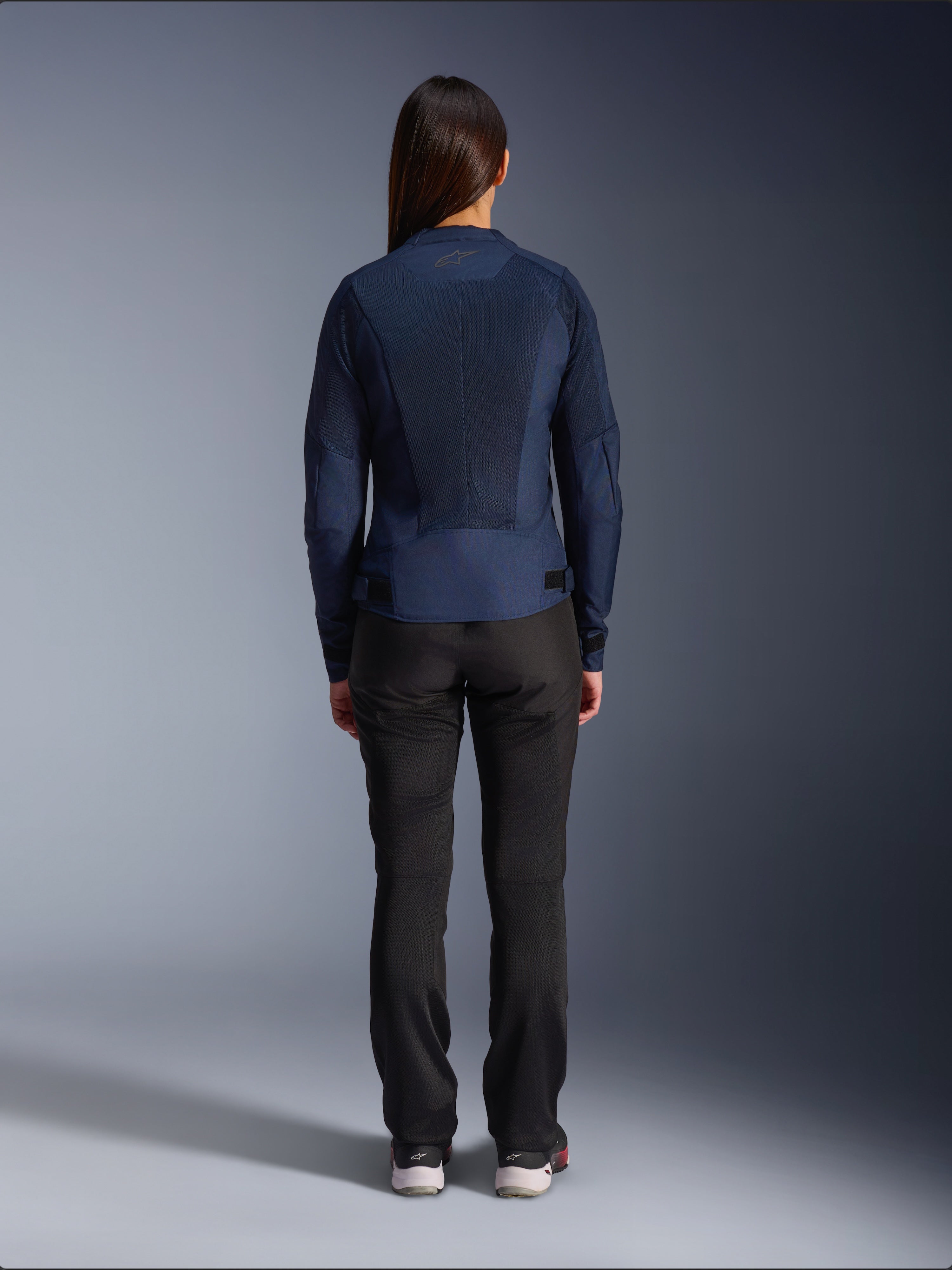 Alpinestars Stella C-1 Air-jakke, tekstil-motorcykeljakke til damer, navyblå, set bagfra med omfattende mesh-paneler til ventilation og Alpinestars-logo på nakken, kombineret med sorte kørebukser for et moderne urbant look