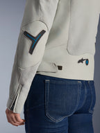 Alpinestars Stella Circal-1 Air damejakke i Metal Gray og Methyl Blue, tætbillede af ryg- og ærmedetaljer med mesh-paneler, neonblå detaljer på albue og talje, justerbar strop, båret med mørkeblå denimjeans