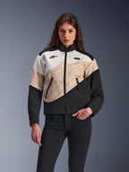 Alpinestars Stella Moshell jakke, urban motorcykeljakke til kvinder, asymmetrisk color-blocked design i sort, sand og off-white, med lynlås foran og sidelommer med lynlås, vist med sorte bukser for et moderne streetwear-look.