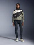 Alpinestars Stella Moshell-jakke, motorcykeljakke til kvinder, sort, grå og off-white med pink detaljer, båret af en model med mørke jeans og off-white sneakers, med et asymmetrisk lynlåsdesign og markant geometrisk grafik, moderne urbant køreudstyr