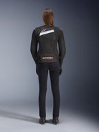 Alpinestars Stella T-GP Plus R V4 Airflow-jakke, sort og hvid, set bagfra med omfattende mesh-ventilationspaneler og Alpinestars-branding, båret af en kvindelig motorcyklist med sorte slim-fit motorcykelbukser og støvler, sport-fit tekstiludstyr til kvinder