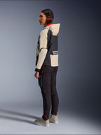 Alpinestars Molly Air-jakke, motorcykeljakke til kvinder, Black Almond, med hættedesign, cremehvide ærmer og sort overdel, båret med sorte kørebukser og beige sneakers, urban moderne stil.