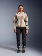 Kvindelig model iført Alpinestars Molly Air-jakke i Sand Pink Almond, kombineret med sorte tekniske kørebukser og støvler, fuldkropsvisning forfra, urban motorcykeljakke med utility-inspireret design og lyserøde detaljer