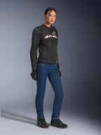 Alpinestars Stella SMX Air-jakke, tekstil motorcykeljakke til kvinder, sort med hvide og røde detaljer, bæres med blå mc-jeans, sorte handsker og sorte mc-sko, sporty urbant køreudstyr til kvinder.