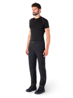 Alpinestars Alden bukser, urbane motorcykelbukser, sorte, regular fit softshell-tekstil, båret af en model med et sort basislag og køresko, med taljebælte med magnetisk lukning og lynlåslommer.