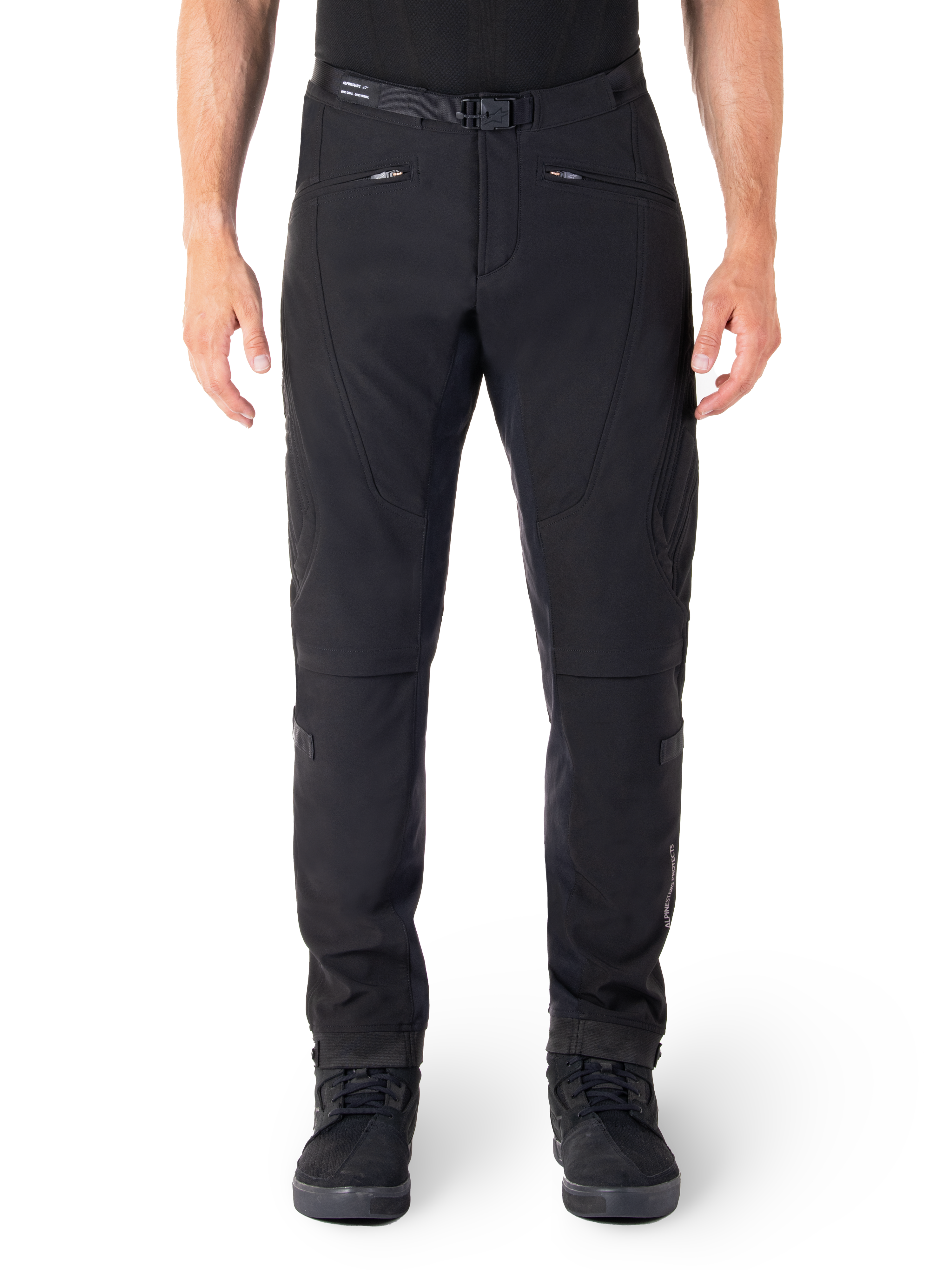 Alpinestars Alden bukser, sorte urban motorcykelbukser, set forfra, teknisk stretch-softshell-stof, integreret bælte med magnetisk spænde, forlommer med lynlås, quiltede knædetaljer, slim-fit silhuet, stylet med sorte køresko