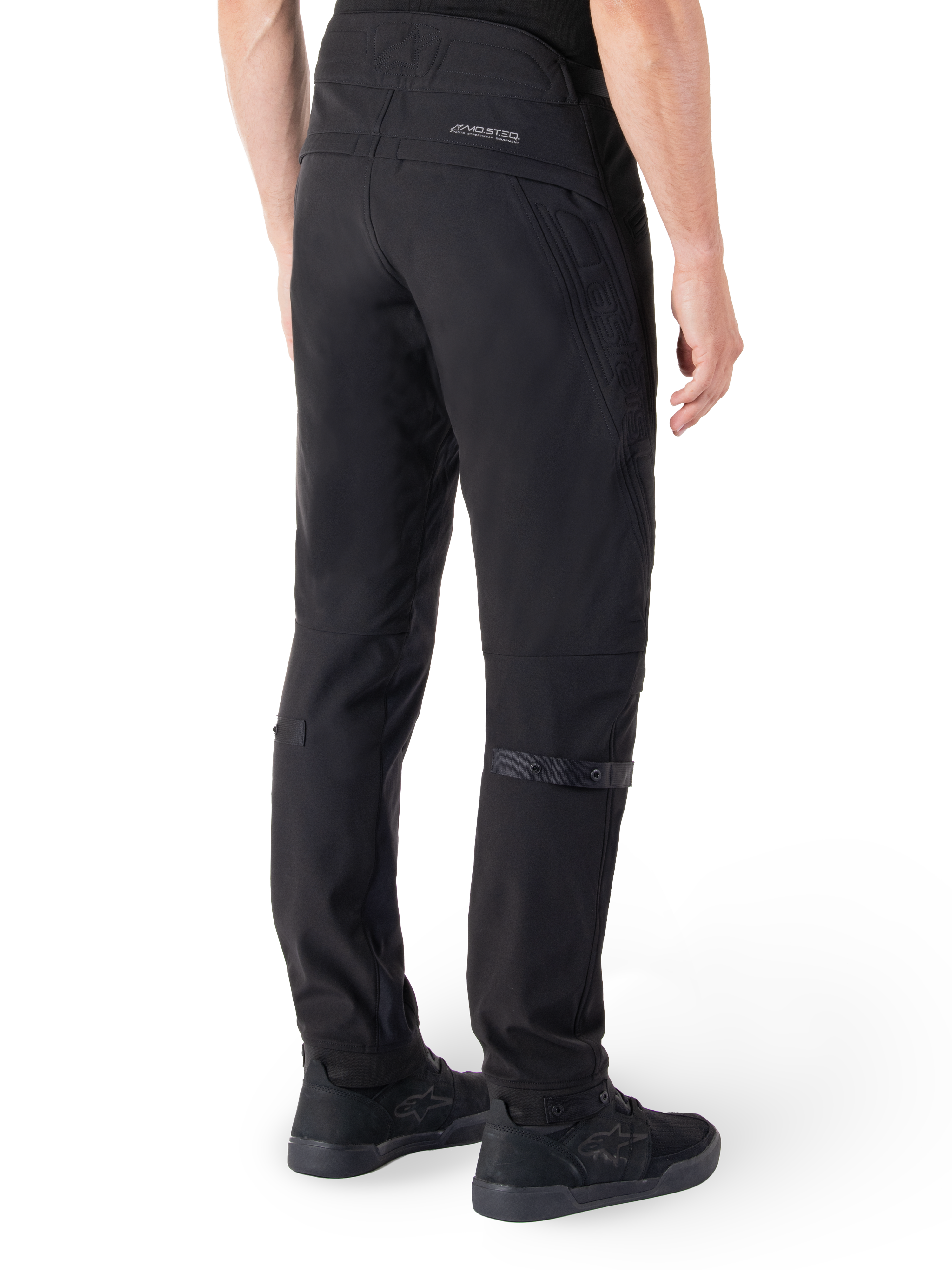 Alpinestars Alden bukser, urbane motorcykelbukser, sort, set bagfra viser teknisk softshell-stof med quiltede detaljer, MO.ST.EQ. reflekterende branding på bagstykket og justerbare lægstropper, kombineret med sorte køresko