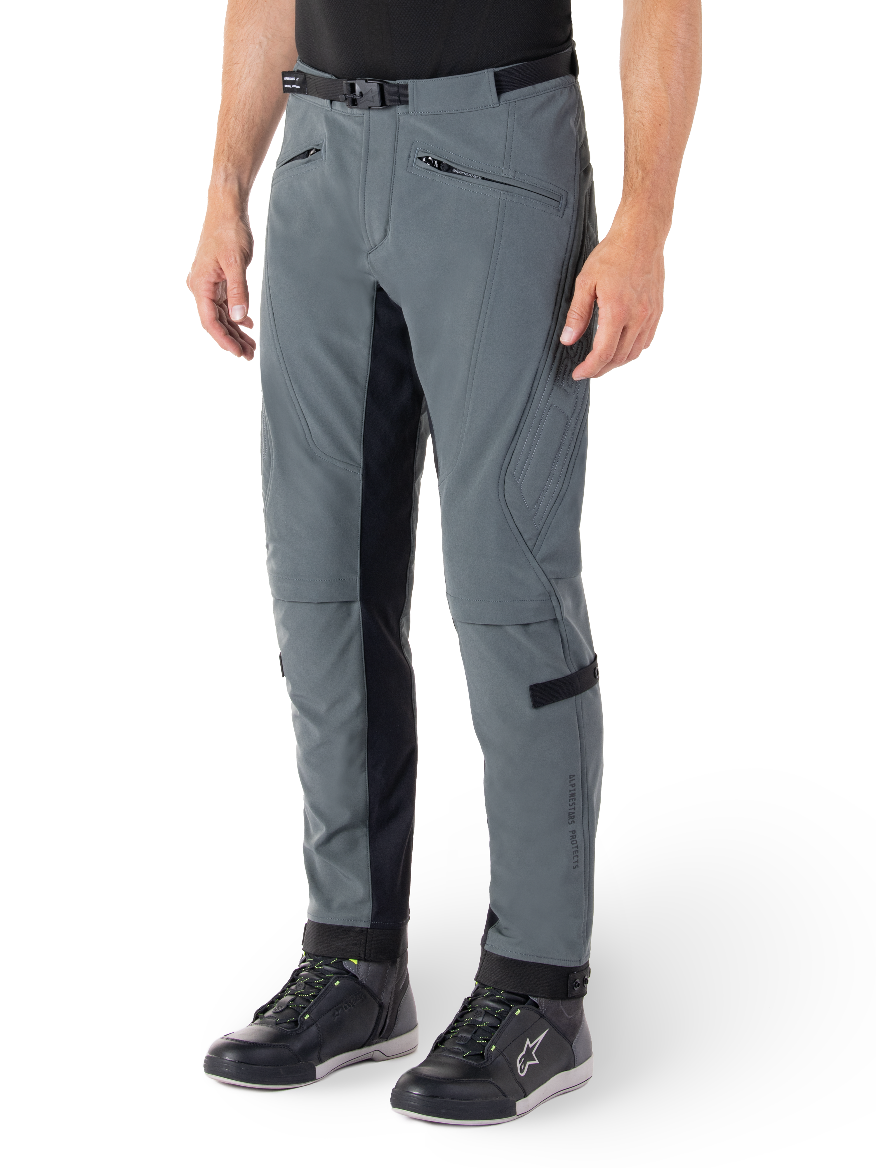 Alpinestars Alden bukser, Urban grå og sorte motorcykelbukser, streetwear-inspirerede tekstilkørebukser med 3-lags stretch-softshell, sorte indvendige benpaneler, indbygget taljebælte, slim fit under knæet, vist med sorte køresko