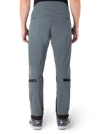 Alpinestars Alden bukser, Urban Gray, set bagfra af urbane motorcykelbukser til mænd, slim fit under knæet med sorte justeringsstropper på læggen, højtaljet design med MO.ST.EQ.-ordmærke på bagstykket, båret med grå køre sko