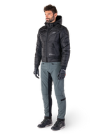 Alpinestars Alden bukser i Urban Gray, båret af en model med sort quiltet hættejakke, handsker og køresko, med quiltede detaljer på siderne og sorte paneler på indersiden af benene, streetwear-inspireret urbant motorcykeludstyr.