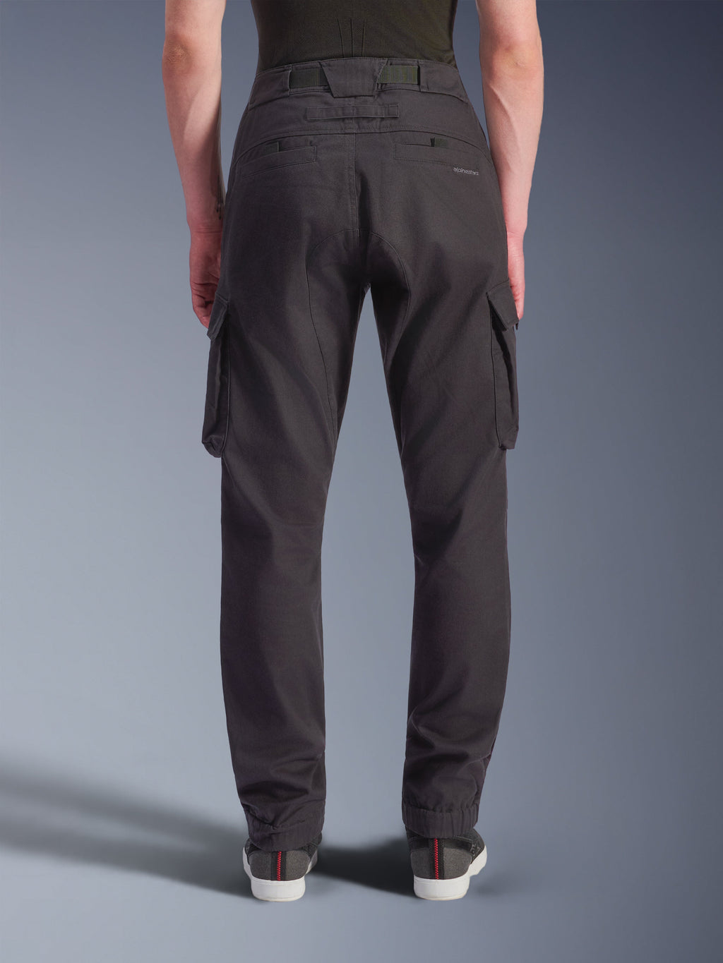 Alpinestars Flex-AST Cargo bukser, sort, set bagfra, tekniske motorcykelbukser med regular smal pasform, elastiske kanter, store cargolommer og diskret branding, designet til urban kørsel.