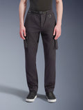 Alpinestars Flex-AST Cargo-bukser, motorcykelbukser, sort, set forfra med regular tapered pasform, cargolommer, integreret bælte med D-ring og elastiske kanter, kombineret med sorte sneakers