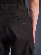 Alpinestars Flex-AST Cargo bukser, urbane motorcykelbukser, sort, nærbillede af bagside og side, der viser baglommen med Alpinestars-branding, klap til cargolomme i siden og holdbar konstruktion i stræktekstil.