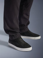 Alpinestars Flex-AST Cargo Pants - Short, urbane motorcykelbukser, sorte, med tilspidsede ben og elastiske sømme, kombineret med sorte Alpinestars sneakers, moderne urban kørestil