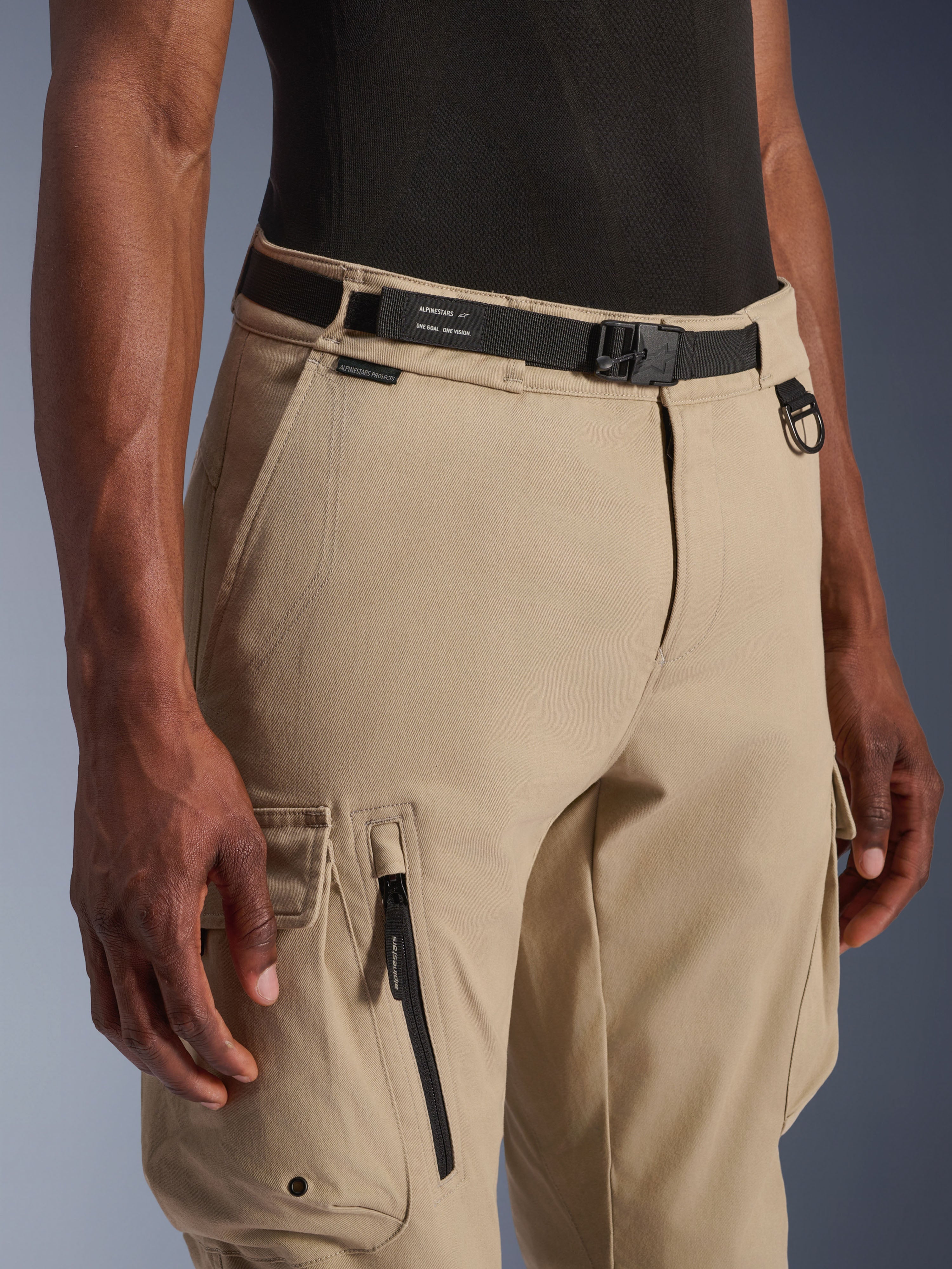 Alpinestars Flex-AST Cargo bukser, motorcykel cargo-bukser, lys beige, med integreret sort gjordbåndsbælte med branding, metal D-ring, sidelomme med lynlås og slidstærkt twill-stof for et funktionelt urbant køre-look