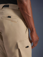 Alpinestars Flex-AST Cargo Bukser - Short, lysebeige, nærbillede fra siden, der viser cargolomme med sort trækstrop og broderet logo på baglommen, slidstærkt tekstilmateriale, urbant motorcykeludstyr.