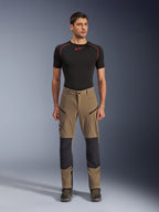 Alpinestars Flex-AST Explorer bukser, motorcykel-touringbukser, valnøddebrun og sort, med forstærkede knæpaneler og lårlommer med lynlås, båret med sort kortærmet base layer, fuldkropsvisning
