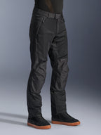 Alpinestars C-1 Air bukser, urbane motorcykelbukser, sort, med åndbare tech-mesh-paneler og polyfabric-konstruktion, båret med sorte sneakers, rent og funktionelt design til bykørsel.