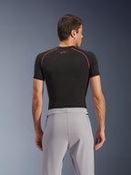 Alpinestars Aeroshell Airflow bukser, mellemgrå, set bagfra, båret med et sort kortærmet basislag med røde syninger og logo, med letvægts stræk-softshell-tekstil og mesh-paneler for maksimal ventilation, ergonomisk sportspasform til motorcykelkørsel.