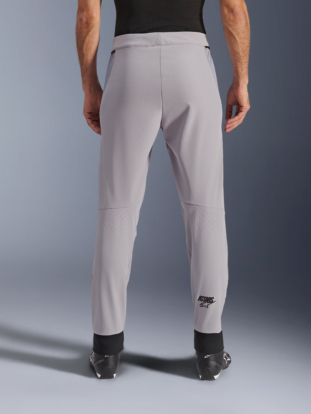 Alpinestars Aeroshell Airflow bukser, motorcykelbukser, Mid Gray, set bagfra med laserperforerede zoner på læggene og sort Astars-logo, tekstil softshell-konstruktion med sorte ankelmanchetter og mesh-paneler på hofterne