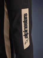Alpinestars Flex-AST Canvas bukser, nærbillede af buksebenets side, sort med Aluminum accentpanel, lodret sort Alpinestars-logo og stjerne-ikon, slidstærkt polybomulds-twill til motorcykelkørsel i byen