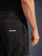Alpinestars Flex-AST Canvas bukser, urban motorcykelbukser, Black Aluminum, nærbillede af bag- og sidelommerne, med broderet Alpinestars-logo, lynlåslomme med mærket trækker, slidstærk konstruktion i stretch-canvas-twill.