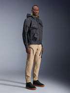 Alpinestars Acteon-bukser, urbane motorcykelbukser, sandfarvede, båret af model med en mørk teknisk jakke og sorte sneakers, med en tilspidset pasform med sorte lynlåsdetaljer og cargolommer, moderne motorsport-inspireret design