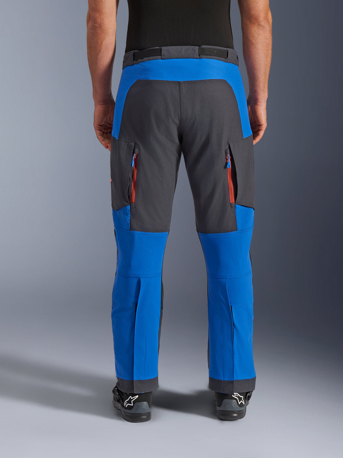 Alpinestars Maxdura Dual bukser, adventure-motorcykelbukser, kongeblå og mørkegrå, set bagfra med lodrette lynlåsudluftninger på lårene og forstærkede sædepaneler, over-støvle-design, teknisk udstyr til dual-sport-kørsel