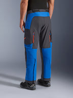 Alpinestars Maxdura Dual bukser, kongeblå og mørkegrå, set bagfra viser lynlåslommer og ventilationszoner, over-støvle design båret med sorte Alpinestars støvler, slidstærkt adventure- og dual-sport køreudstyr