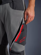Alpinestars Maxdura Dual bukser, mørkegrå og Deep Gray adventure motorcykelbukser, nærbillede af åben lårventilation med lynlås, røde detaljer og broderet rødt stjernelogo, teknisk strækstofdesign