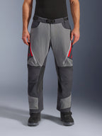 Alpinestars Maxdura Dual bukser, adventure motorcykelbukser, mørkegrå og dyb grå med røde detaljer, set forfra med lynlåsåbninger på lårene, magnetisk spændebælte og forstærkede knæpaneler, over-støvle design til dual-sport kørsel.
