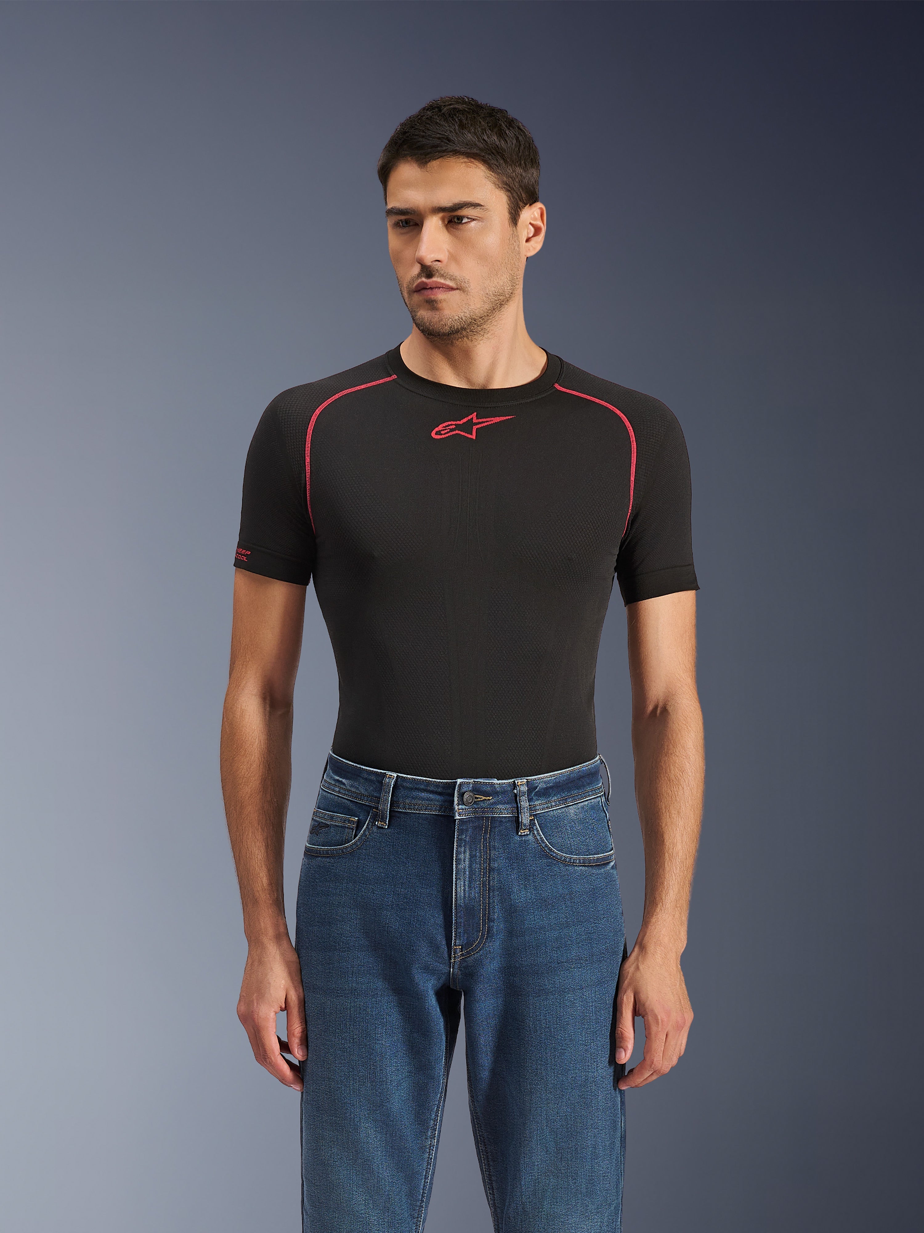 Alpinestars Flex-AST 5 Denim Pants in Indigo Washed, urban motorcycle jeans with a tapered fit, worn by a male model with a black short-sleeved base layer featuring red accents, casual road-to-street styling
