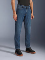 Alpinestars Flex-AST 5 Denim bukser, Indigo Washed motorcykeljeans, regular tapered fit, båret med sorte high-top sneakers og en sort trøje, afslappet urbant køreudstyr med et klassisk denim-udseende.