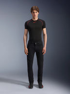 Alpinestars Copper V3 Denim bukser i Black Rinse, regulær pasform med lige ben, båret af en mandlig model med en sort base layer t-shirt med røde kontrastsyninger og sorte køresneakers, urbant motorcykeludstyr
