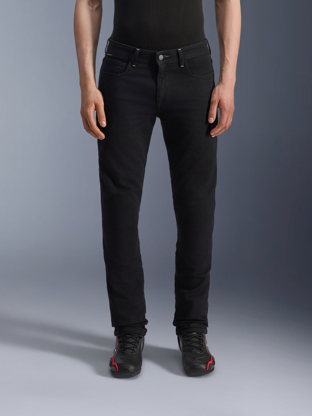 Alpinestars Copper V3 denimbukser, Black Rinse motorcykeljeans, regulær komfortabel pasform med lige ben, forlommer og bæltestropper, vist på model med sort-røde sneakers, premium køre-denim til bypendling