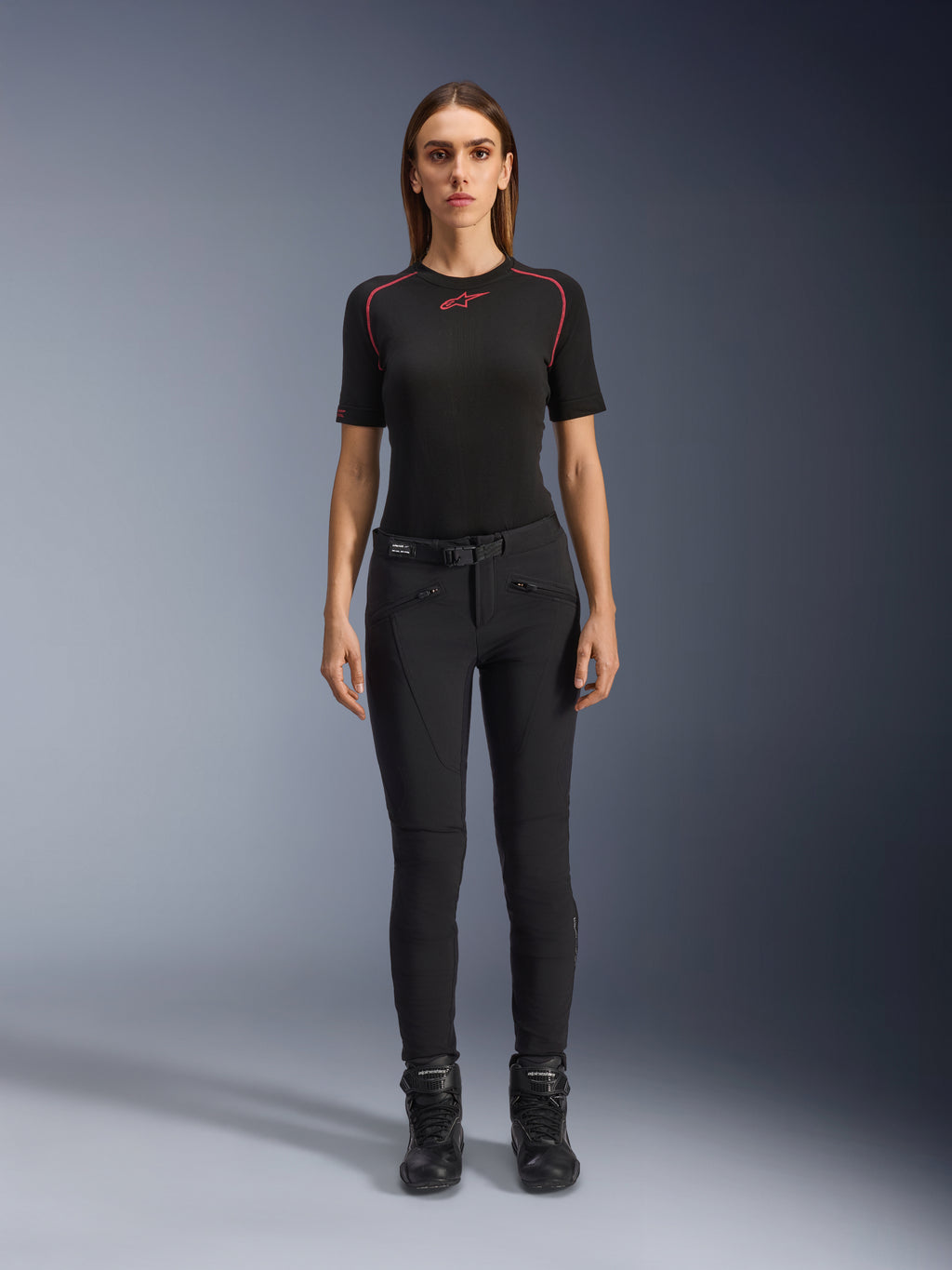 Alpinestars Alamosa damebukser, sorte motorcykelbukser i slim-fit, vist på en model set forfra, med lynlåslommer foran og integreret taljebælte, minimalistisk streetwear-inspireret stil til urban kørsel