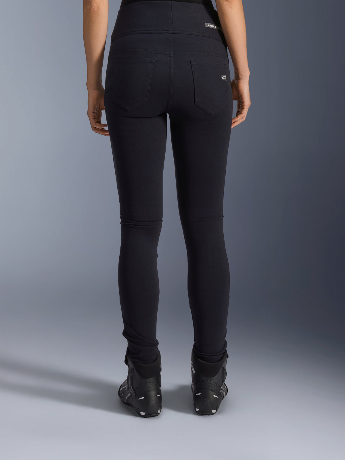 Alpinestars Stella Flex-Ast leggings, motorcykel-leggings til damer, sort, set bagfra med baglommer og slim fit pasform, kombineret med sorte motorcykelstøvler, urban kørestil