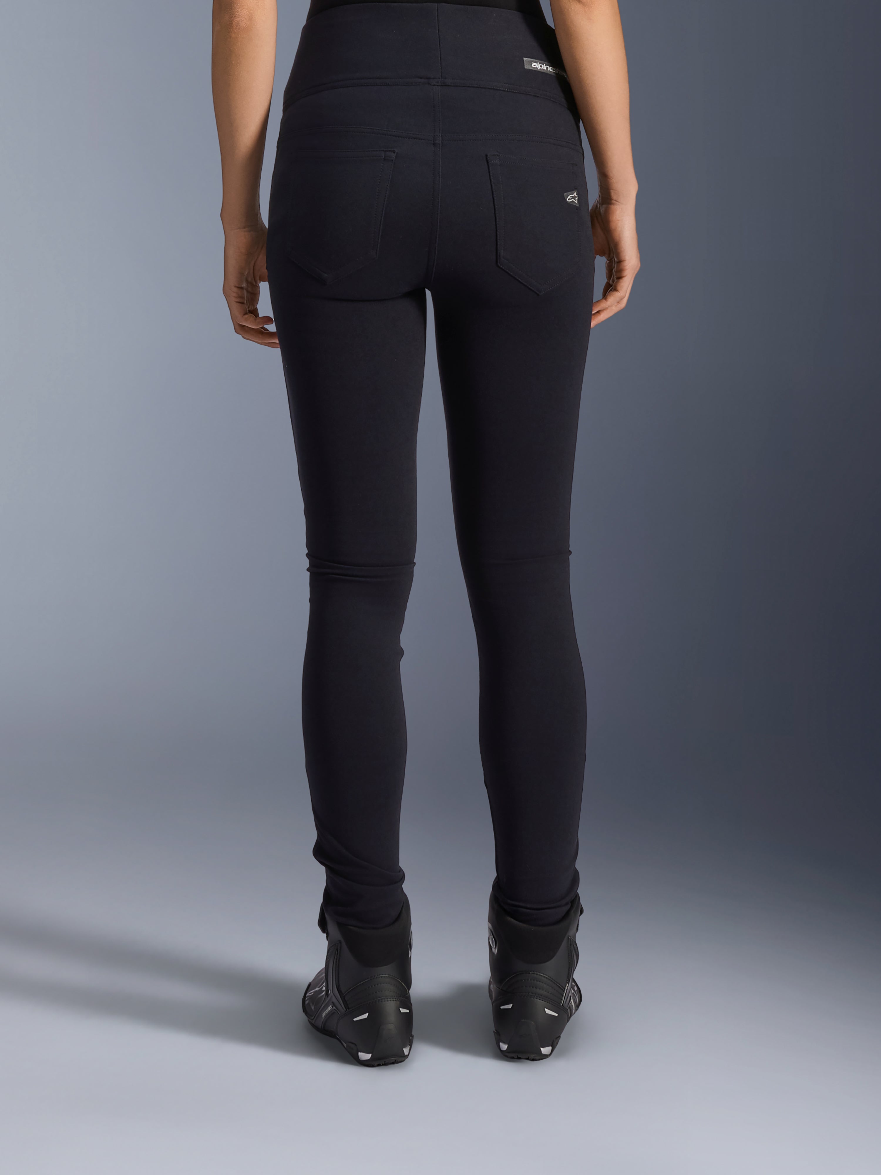 Alpinestars Stella Flex-Ast leggings, motorcykel-leggings til damer, sort, set bagfra med baglommer og slim fit pasform, kombineret med sorte motorcykelstøvler, urban kørestil